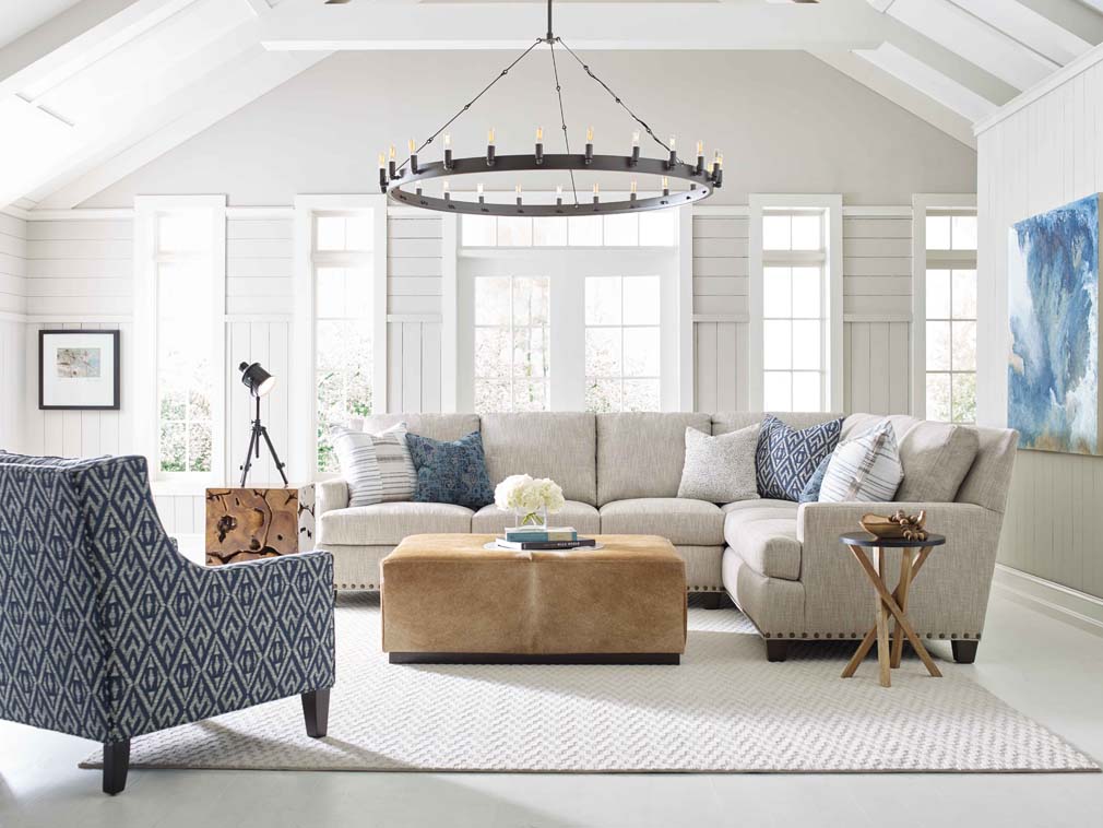 Large modern chandelier hanging in an open concept living room with tall ceilings.