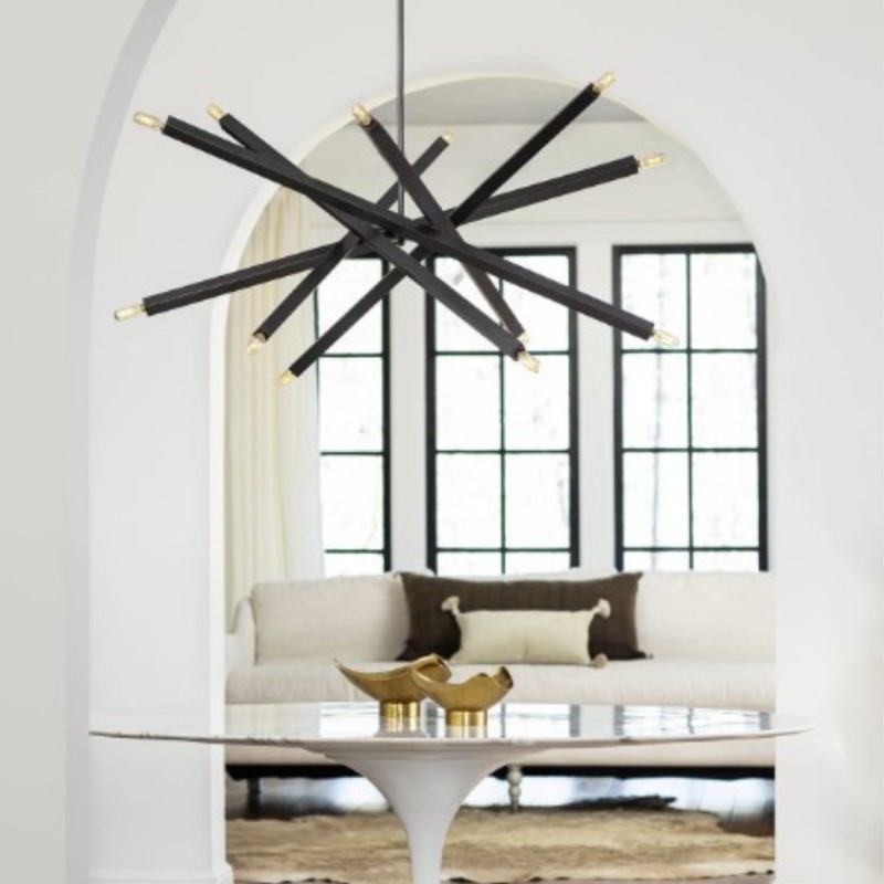 Modern starburst chandelier above a sculptural table in a luxury living room, available at a Denver furniture showroom.