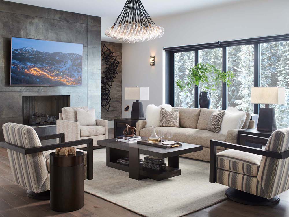 Modern chandelier above a luxury living room with sofa, accent chairs, and fireplace in a contemporary Colorado mountain home.
