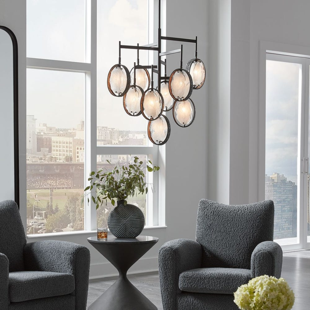 Luxury modern chandelier hanging above accent chairs in a bright living room setting in a Denver home furnished by a luxury furniture store in Denver.